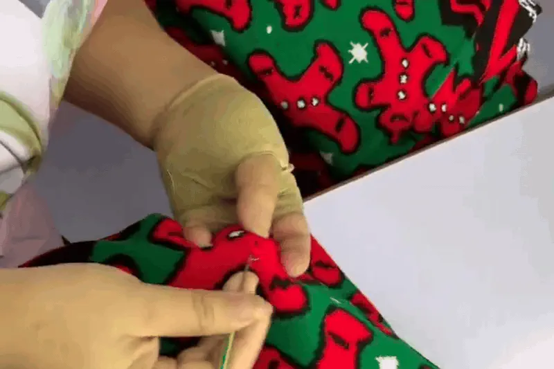 Buyer checking custom Christmas jumper artwork and sample details before bulk production