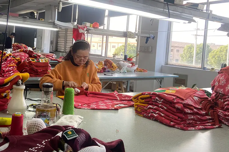 Buyer checking the hand feel of a cotton blend Christmas jumper sample