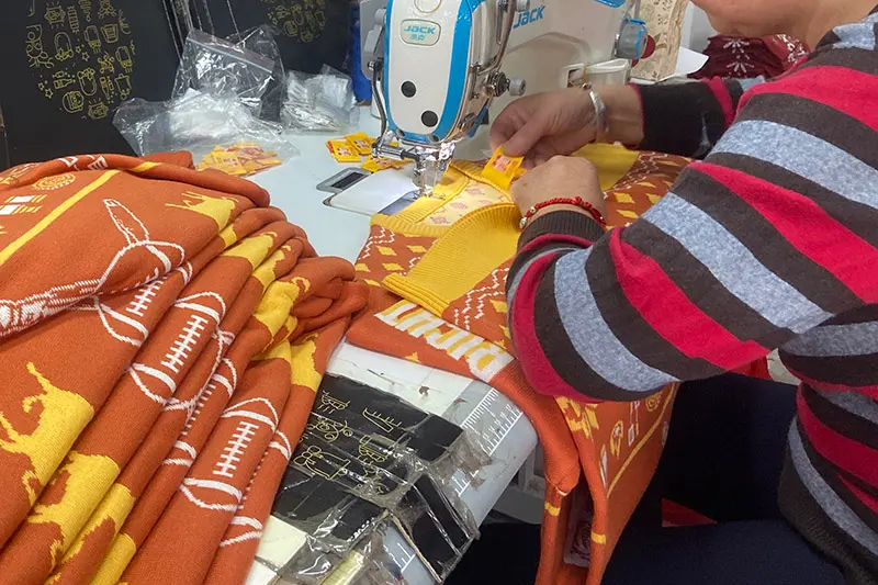 Buyer reviewing an acrylic Christmas jumper sample before bulk production