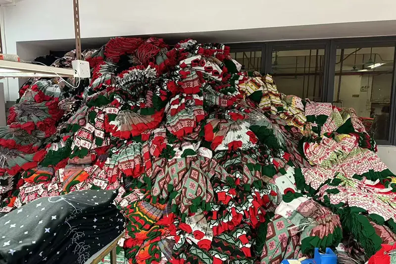 Folded acrylic Christmas jumpers prepared for size sorting and bulk packing